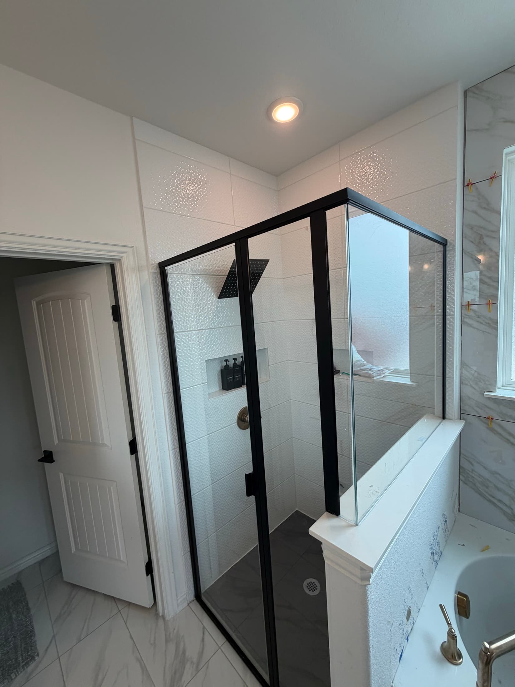 Master bathroom with marble tile and frameless glass shower