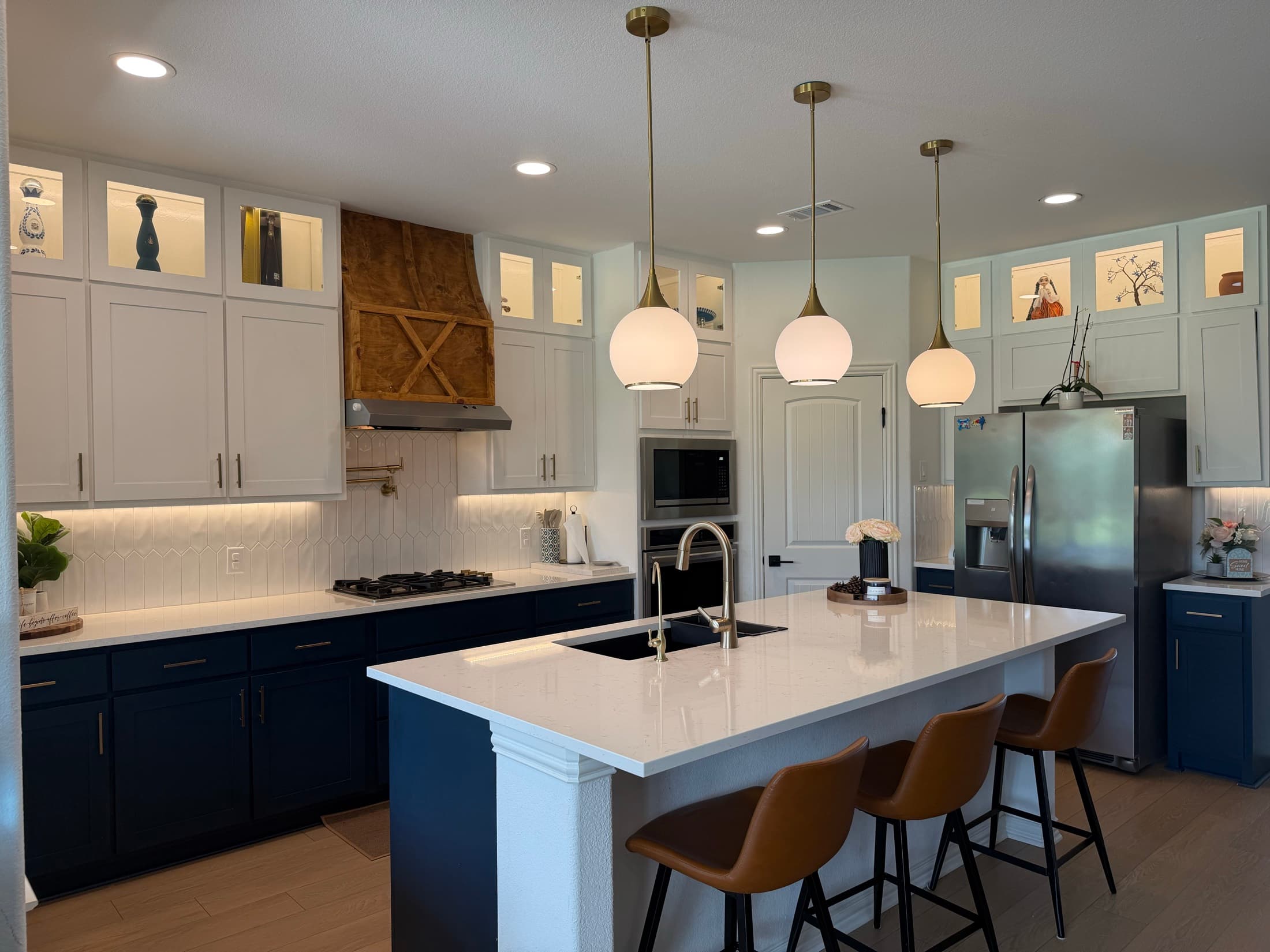 Modern kitchen remodel with navy cabinets and white island by Osso Construction